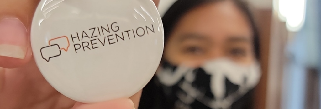Student holding a Hazing Prevention pin